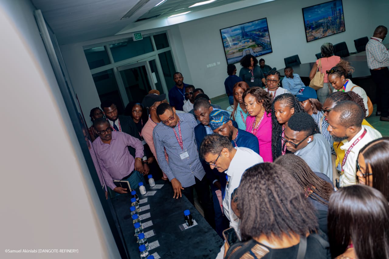 Staff explaining the different components obtained after crude oil refining to James Hope University staff and students present during the visit.